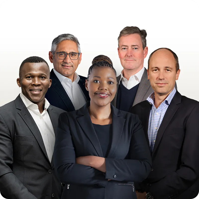 Group of five business professionals standing together and smiling, dressed in formal attire.